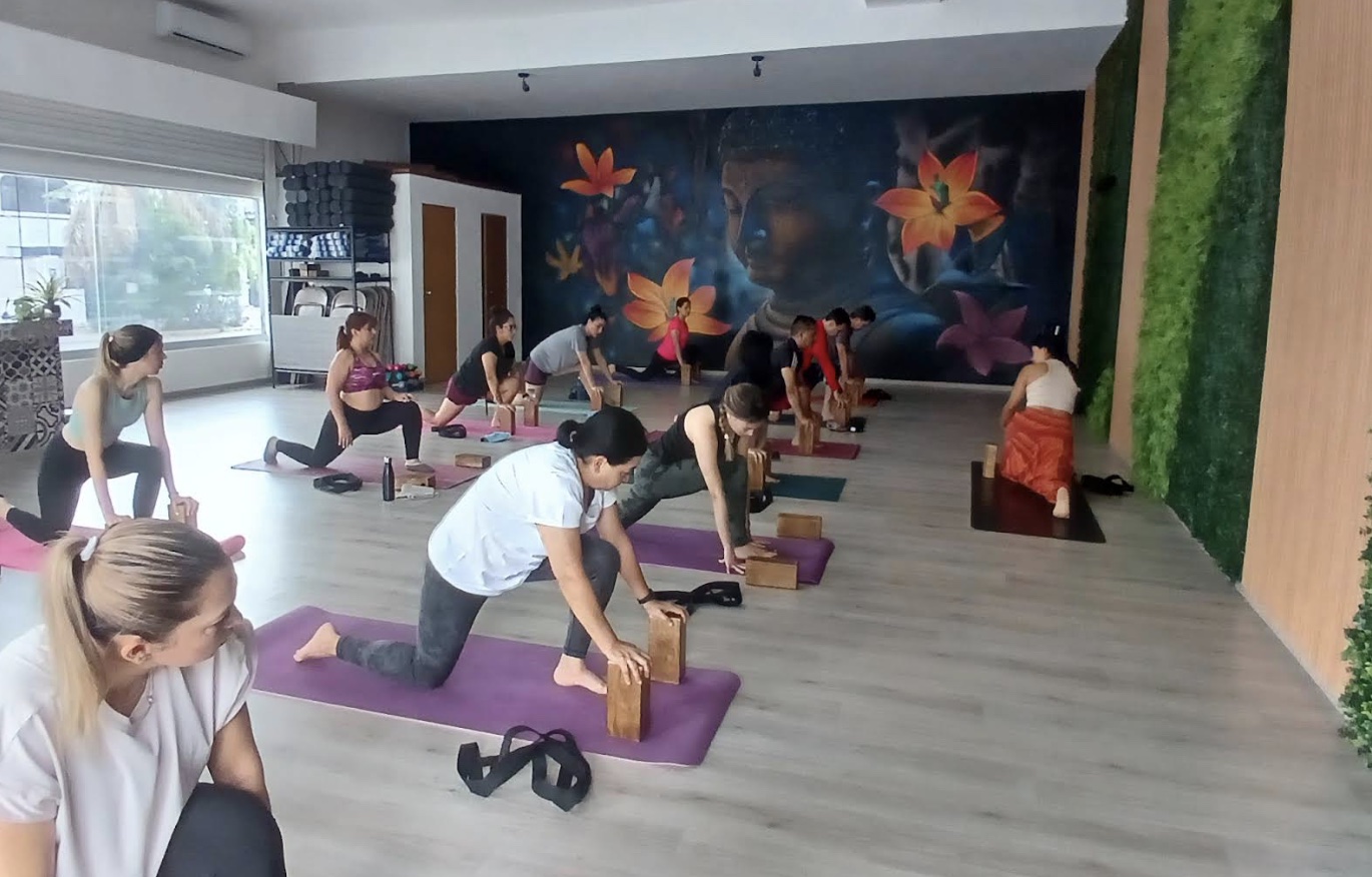 Clase grupal de yoga en Apurva Ladrón de Guevara frente a un mural