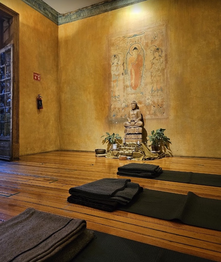 Espacio de meditación con cojines y altar en el Centro Budista de la Ciudad