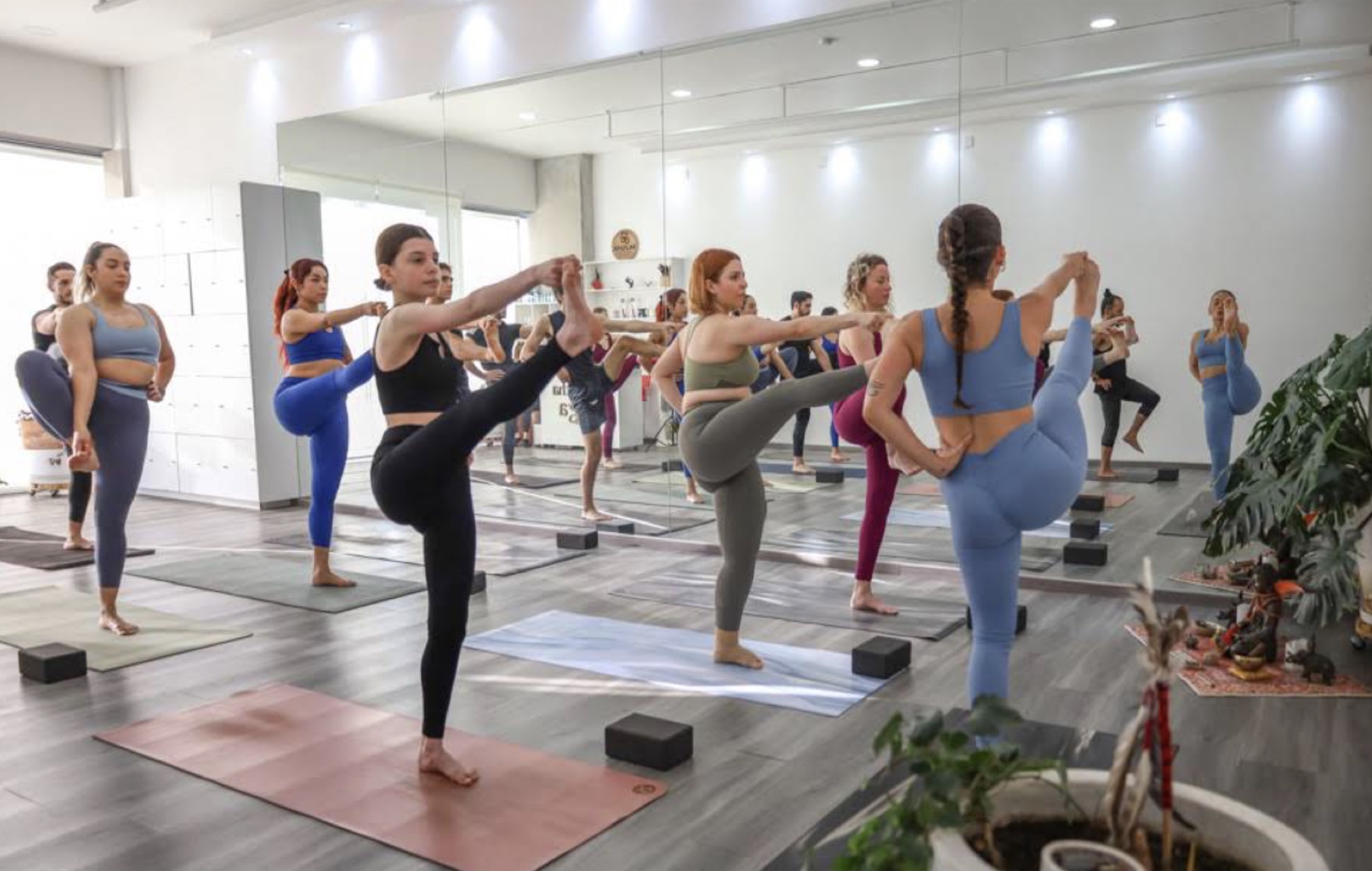 Clase grupal de yoga frente a los espejos de Dhakatha Yoga