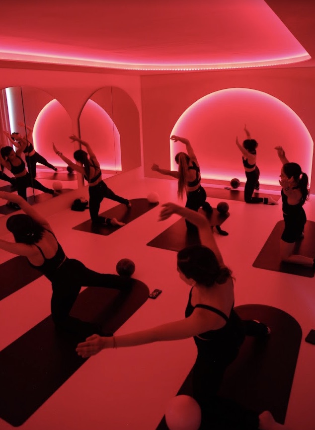 Clase grupal en FIRA Wellness Club con iluminación roja