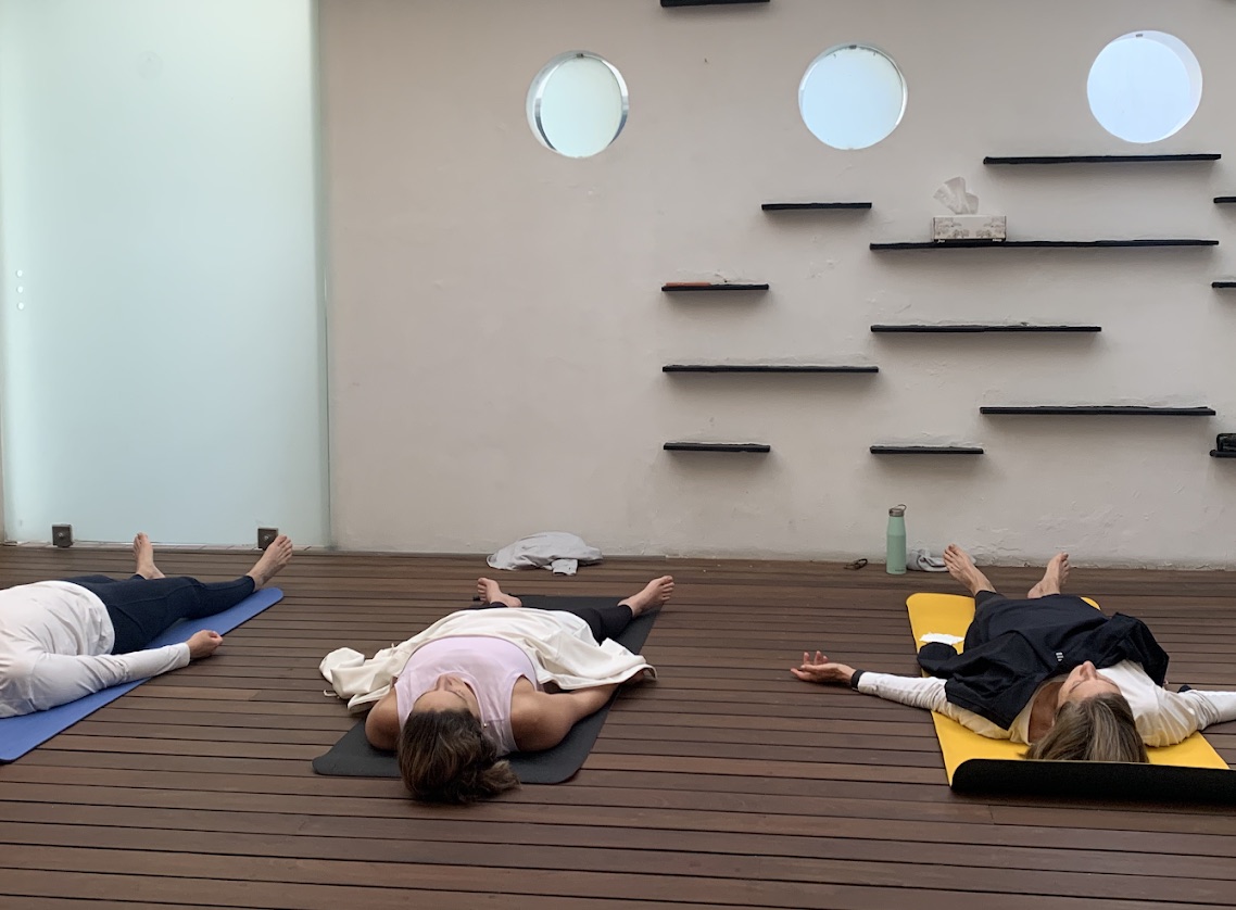 Personas descansando sobre tapetes en Gurukul Yoga Studio Polanco