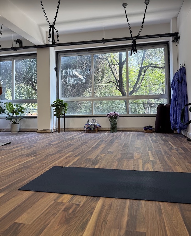 Interior de Kurunta Yoga con piso de madera, ventanales y cuerdas para practicar