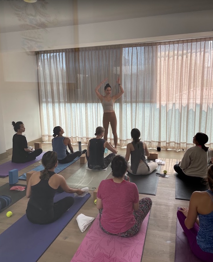 Sesión guiada en el salón de Light On Yoga junto a ventanales
