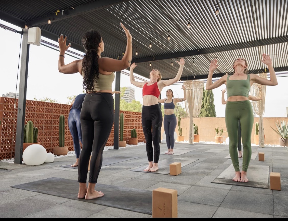 Clase grupal de yoga en una terraza de Light On Yoga