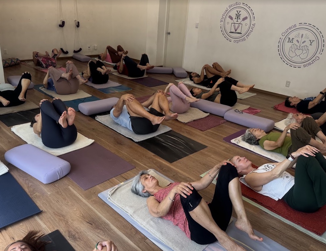 Clase de yoga con cojines y soportes en Metta Yoga
