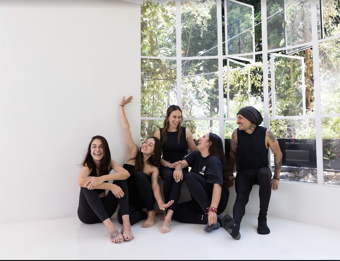 Grupo de personas junto a los ventanales de One Percent Yoga