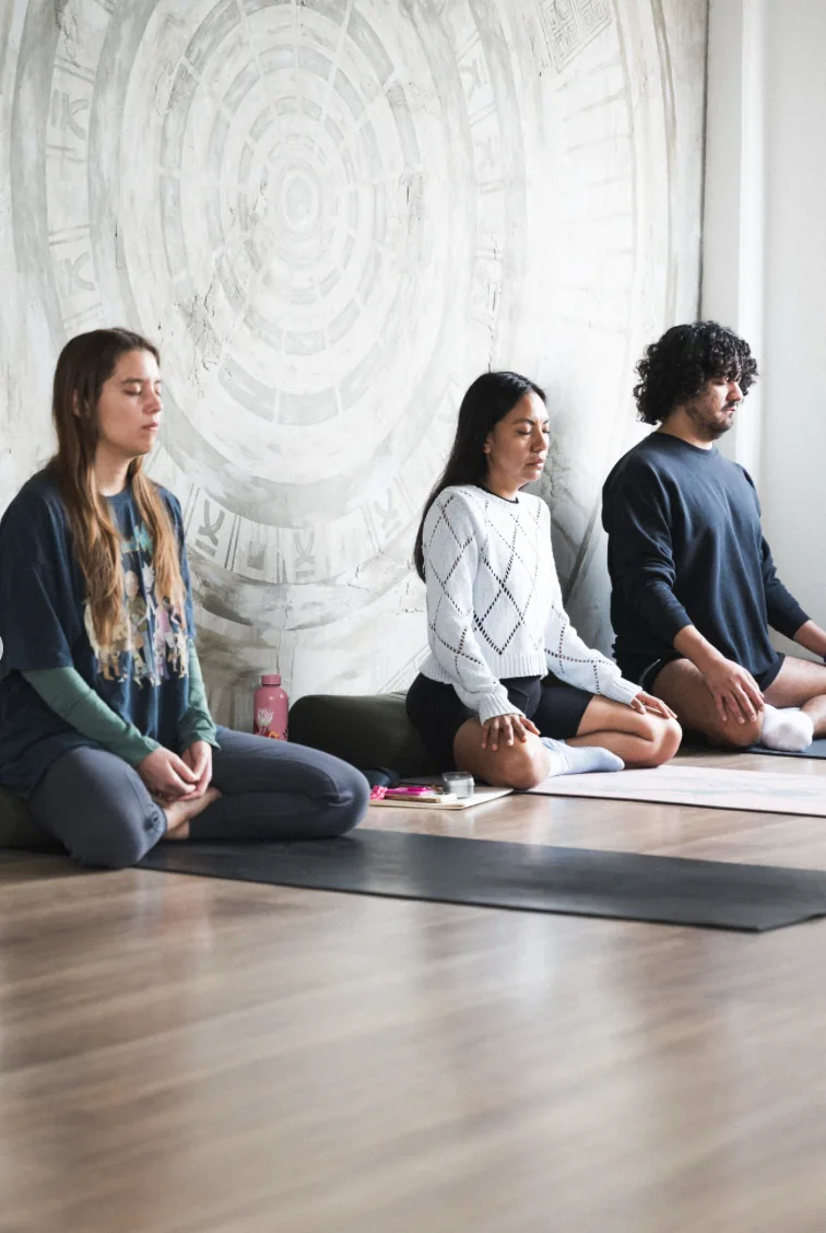 Personas meditando durante una práctica en Mūla Yoga Shala